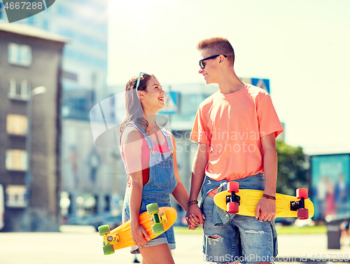 Image of teenage couple with skateboards on city street