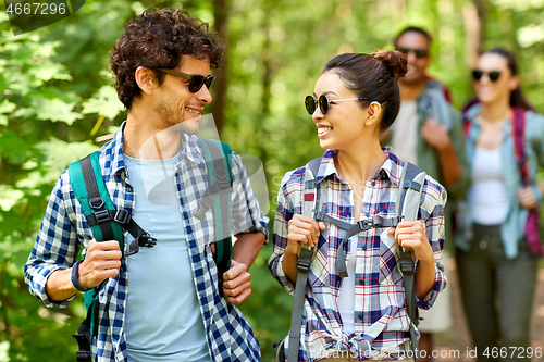 Image of group of friends with backpacks hiking in forest