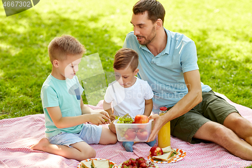 Image of happy family having picnic at summer park