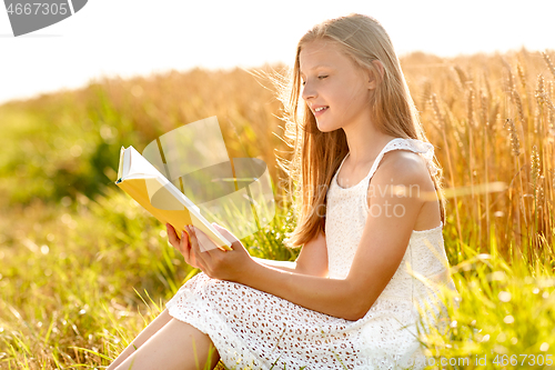 Image of smiling young girl reading book on cereal field