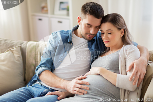 Image of man hugging pregnant woman at home