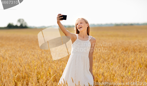 Image of happy young girl taking selfie by smartphone