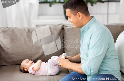 Image of middle aged father playing with baby at home