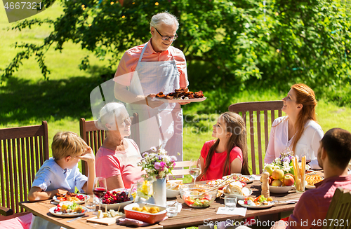 Image of happy family having dinner or summer garden party