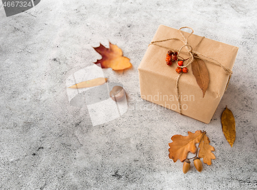 Image of gift box, autumn leaves, acorns and rowanberry