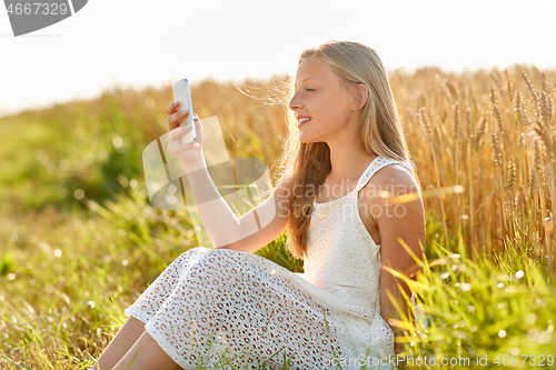 Image of happy young girl taking selfie by smartphone