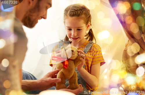 Image of happy family playing with toy in kids tent at home