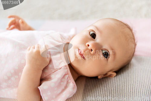 Image of sweet baby girl lying on knitted blanket