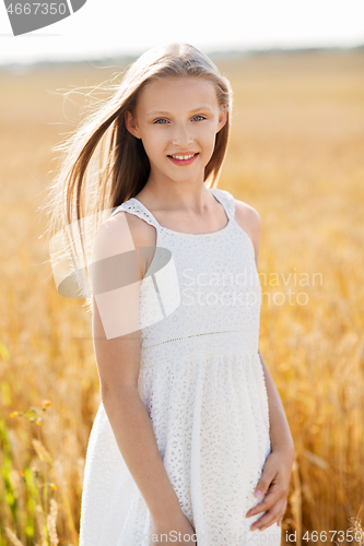 Image of smiling young girl on cereal field in summer