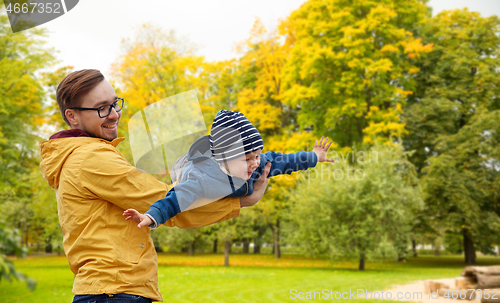 Image of father with son playing and having fun in autumn