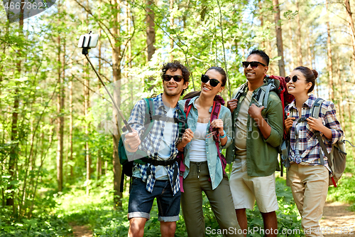 Image of friends with backpacks hiking and taking selfie