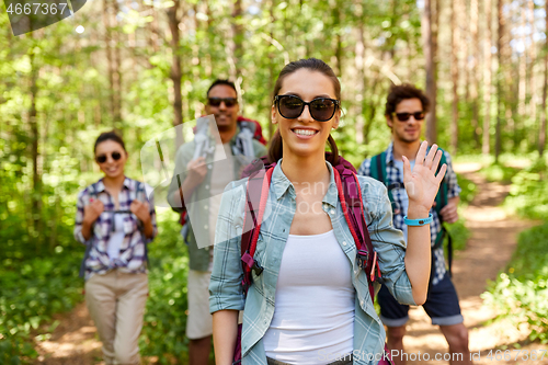 Image of friends with backpacks on hike in forest