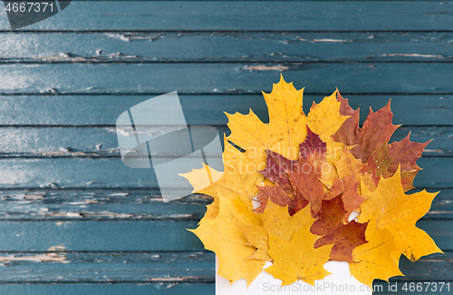 Image of autumn maple leaves with envelope on old boards