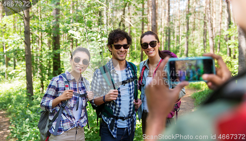 Image of friends with backpacks being photographed on hike