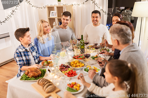 Image of happy family having dinner party at home