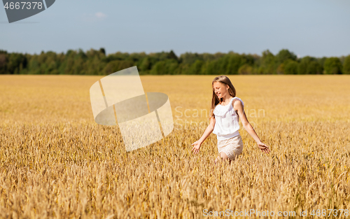 Image of smiling young girl on cereal field in summer