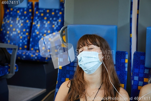 Image of Young woman on a train wearing masks