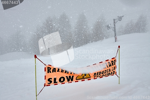 Image of Ski slop warning sign in heavy snowing