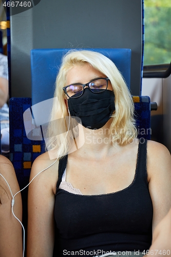 Image of Young woman on a train wearing masks