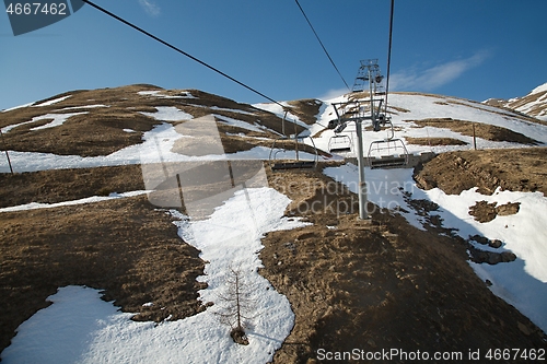 Image of Ski lift at a ski resort with little snow