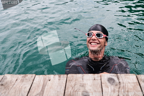 Image of triathlete swimmer portrait wearing wetsuit on training