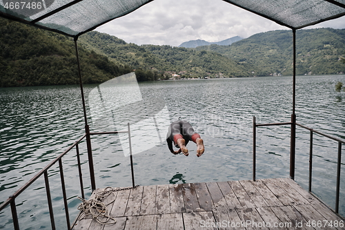 Image of triathlon athlete jumping in water and starting with training