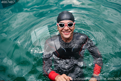 Image of triathlete swimmer portrait wearing wetsuit on training