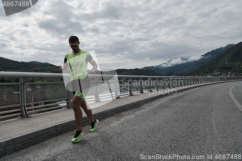 Image of triathlon athlete running on street