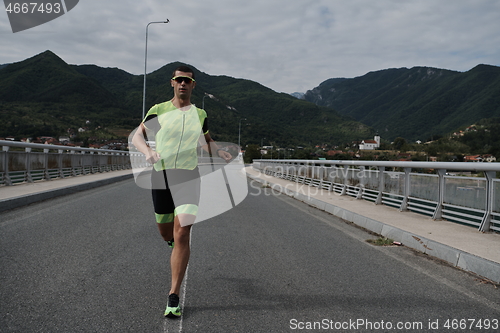 Image of triathlon athlete running on street