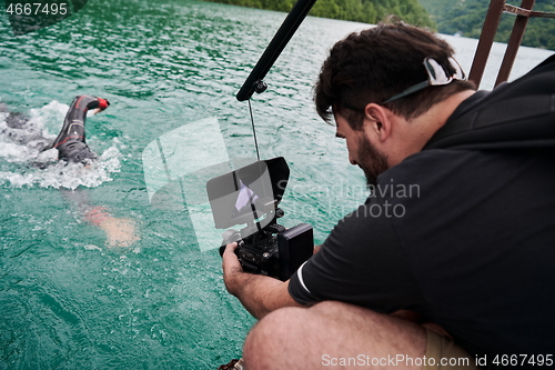 Image of videographer taking action shot of triathlon swimming athlete