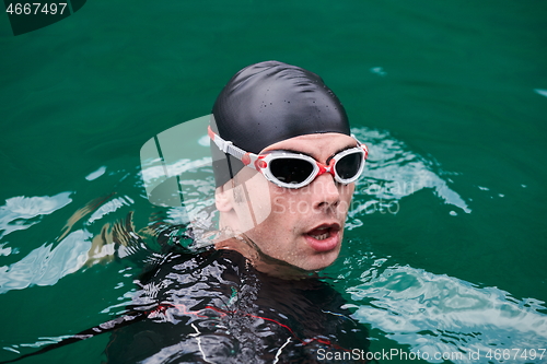 Image of triathlon athlete swimming on lake wearing wetsuit