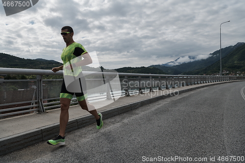 Image of triathlon athlete running on street