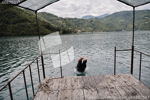 Image of triathlon athlete jumping in water and starting with training