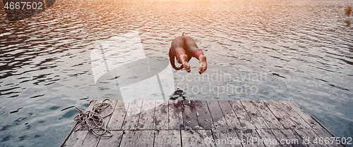 Image of triathlon athlete jumping in water and starting with training