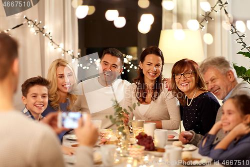 Image of family having tea party and photographing at home