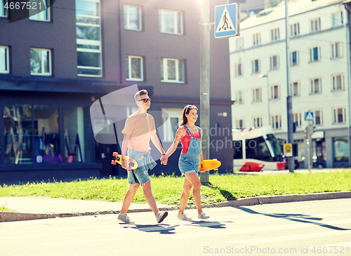 Image of teenage couple with skateboards on city street