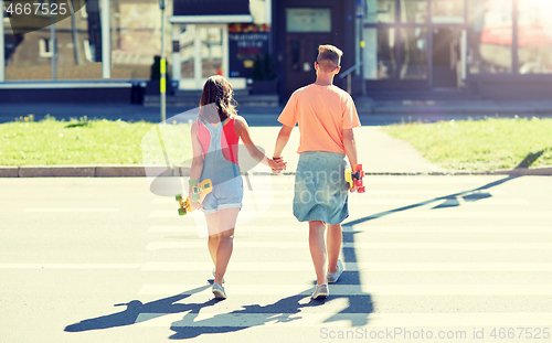 Image of teenage couple with skateboards on city crosswalk