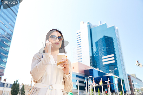 Image of asian woman calling on smartphone in city