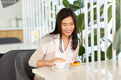 Image of asian woman eating cake with coffee at cafe