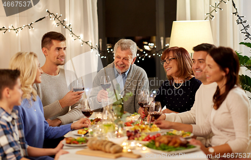 Image of happy family having dinner party at home