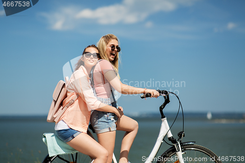 Image of teenage girls or friends riding bicycle in summer