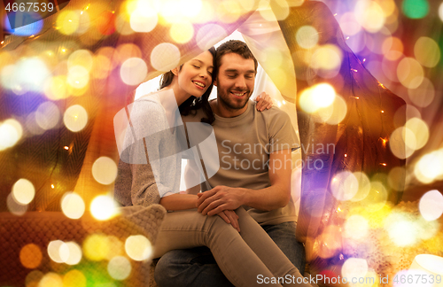 Image of happy couple in kids tent at home