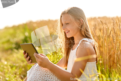 Image of smiling with tablet computer on cereal field