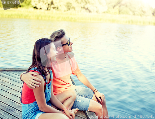 Image of happy teenage couple hugging on river berth