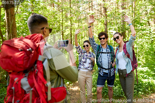 Image of friends with backpacks being photographed on hike