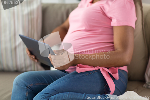 Image of close up of pregnant woman with tablet pc at home