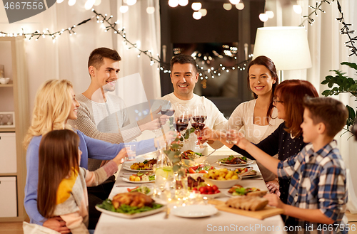 Image of happy family having dinner party at home