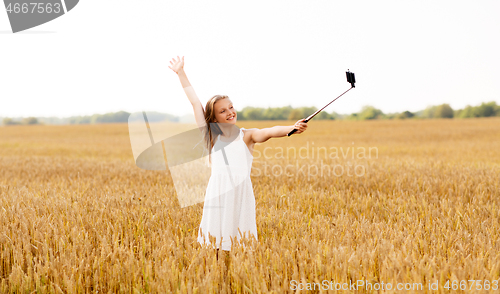 Image of happy young girl taking selfie by smartphone