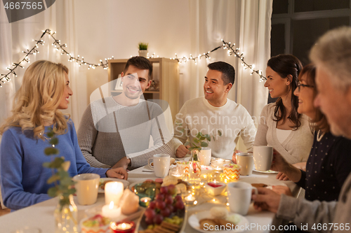 Image of happy family having tea party at home