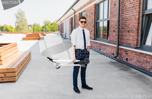 Image of businessman with folding scooter on rooftop